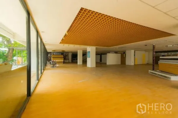 Retail Space for rent in Watthana, Bangkok - Open-plan showroom with full-height glass frontage and a feature grid ceiling.