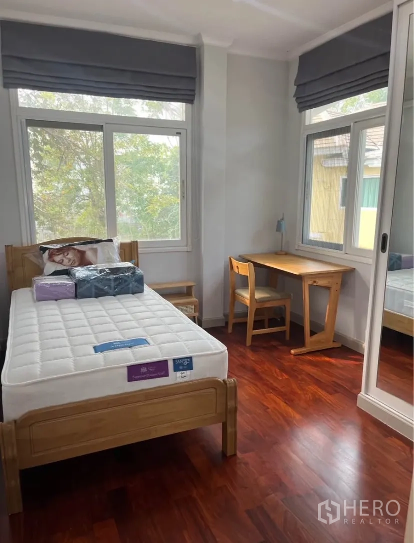 Detached House for rent or sale in Lat Phrao, Bangkok - Secondary bedroom with single bed, study desk and wide windows.