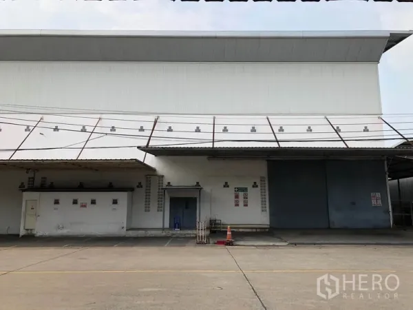 Factory for rent in Bang Bua Thong, Nonthaburi - Close view of factory loading dock with large sliding steel door and metal canopy.