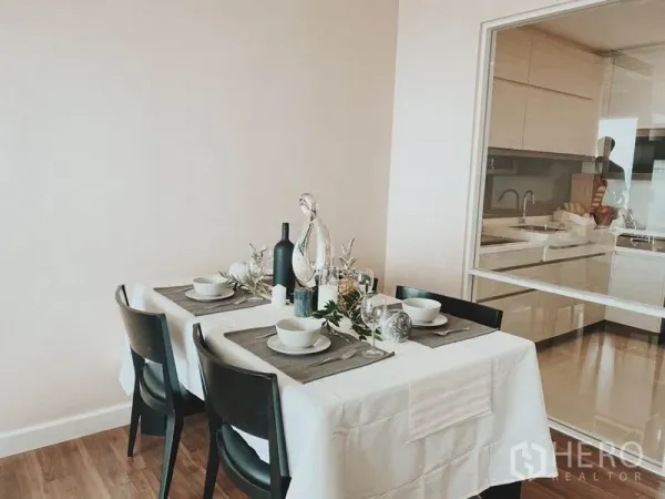 Condominium for rent in Thon Buri, Bangkok - Cozy dining area for four beside a glass-partitioned modern kitchen.