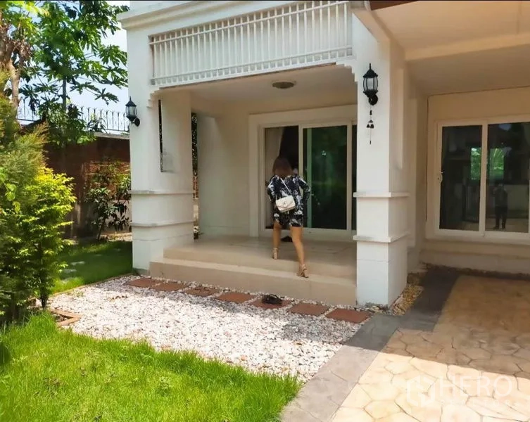 Detached House for rent or sale in Bang Yai, Nonthaburi - Covered front porch with steps, wall lamps and sliding glass doors overlooking the lawn.