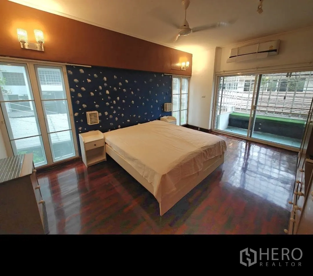 公寓 for rent in Sathon, Bangkok - 卧室设大床、木地板、吊扇与空调，并可通往阳台。