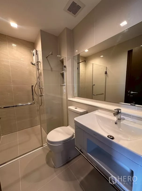 公寓 出租在Chatuchak, Bangkok - 现代浴室，玻璃淋浴间、洗手台与坐便器。