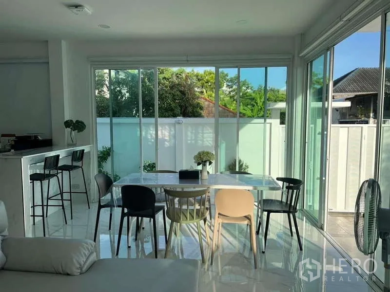 Detached House for rent in Lat Krabang, Bangkok - Dining area with panoramic windows next to a breakfast bar and garden view.
