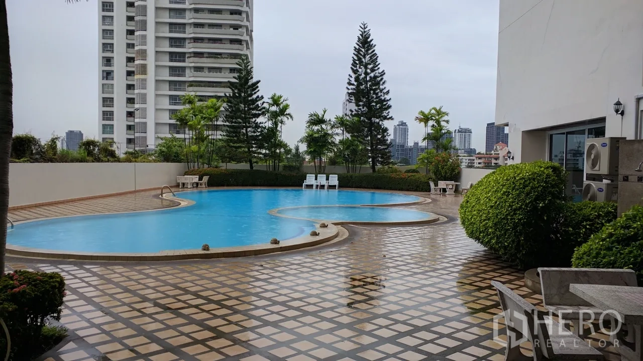 Condominium for rent or sale in Watthana, Bangkok - Outdoor condo swimming pool with city skyline backdrop and sun loungers
