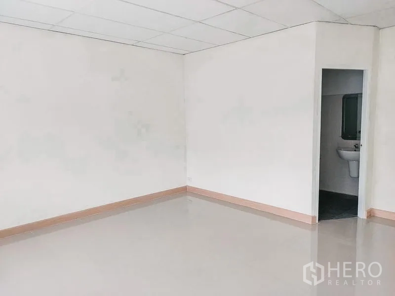 Townhouse for rent in Chatuchak, Bangkok - Spacious room with doorway to an ensuite bathroom, light walls and tiles.