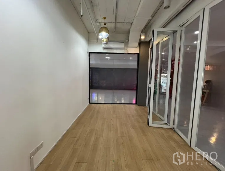 Retail Space for rent in Pathum Wan, Bangkok - Back section of the shop showing split-type air conditioner, pendant lights, and a window to the atrium.