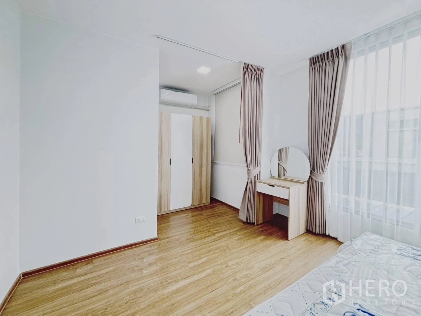 Townhouse for rent in Bang Phli, Samut Prakan - Master suite corner with wardrobe and round-mirror dressing table by the window.