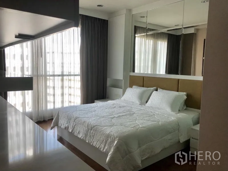 公寓 出租在Pathum Wan, Bangkok - 宽敞卧室，镜面床头墙与转角窗，大床。