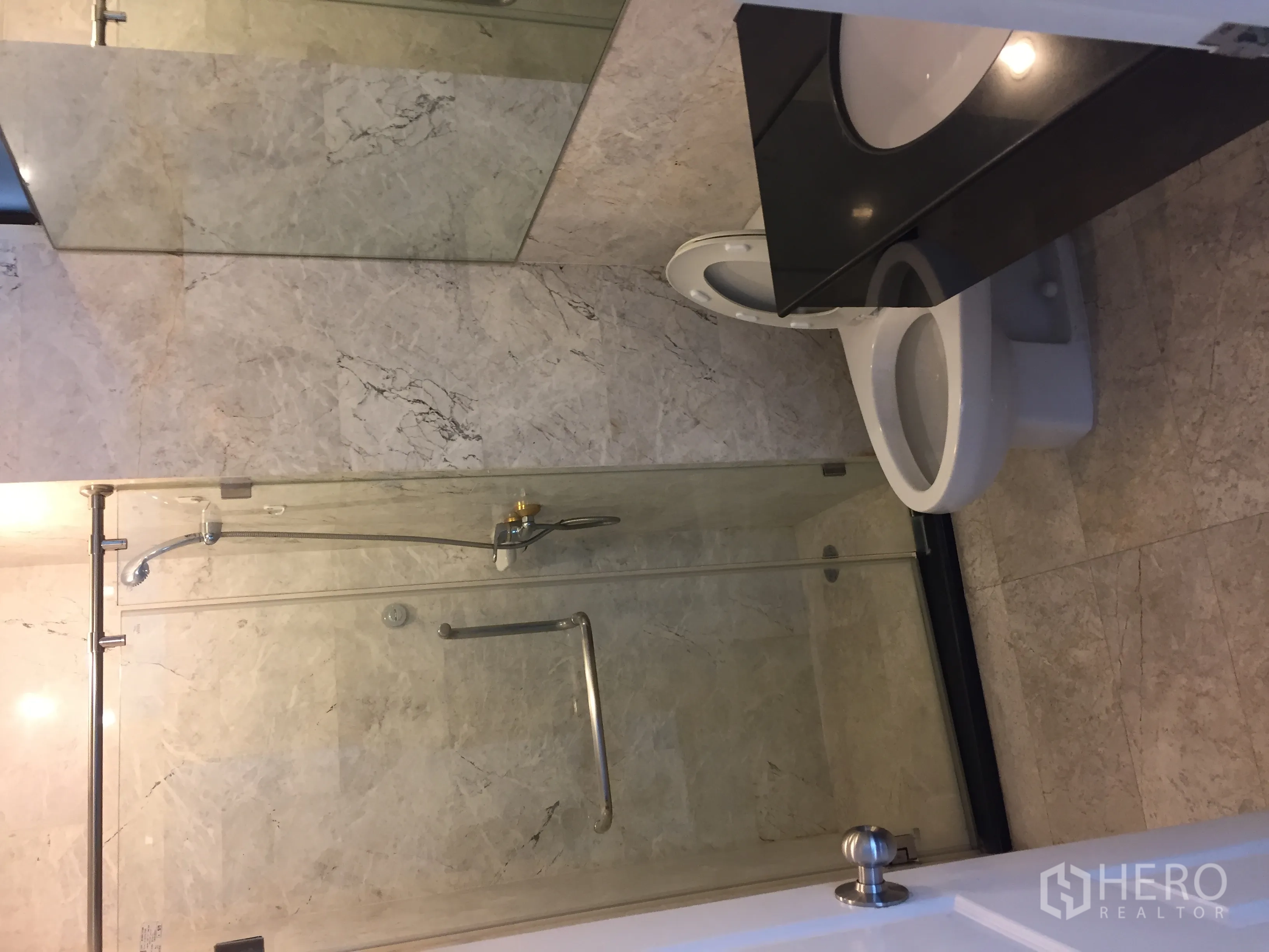 Condominium for rent in Watthana, Bangkok - Second bathroom with glass-enclosed shower, marble-look tiles and modern vanity.