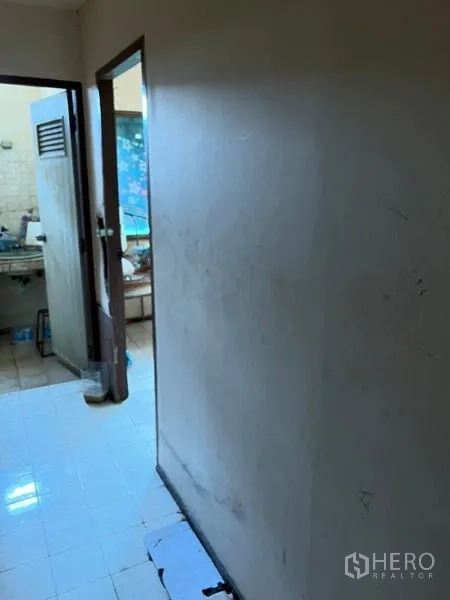 店屋 出租在Watthana, Bangkok - 走廊通向简易厨房与杂物区，墙面为瓷砖。
