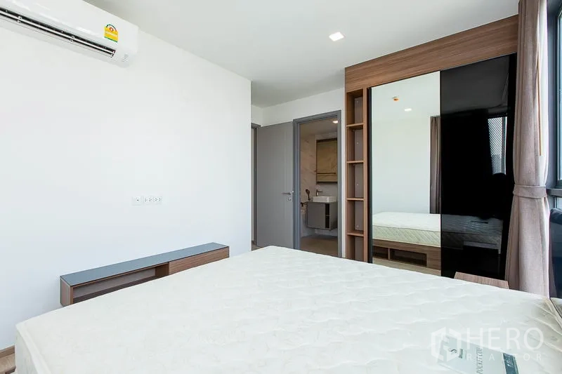 公寓 出租在Watthana, Bangkok - 卧室带内置衣柜与镜面滑门，可通往套内卫浴。