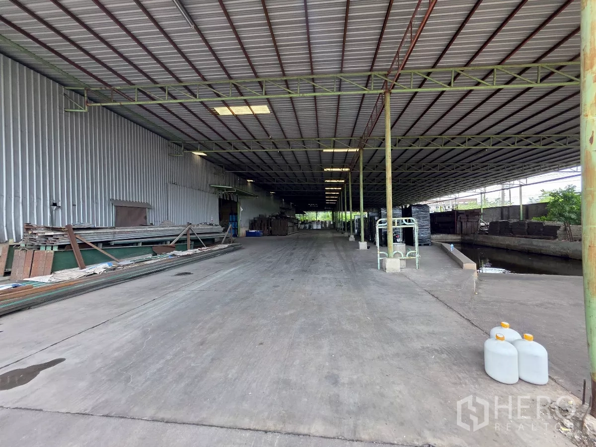 โรงงาน ให้เช่าในMueang Samut Sakhon, Samut Sakhon - ลานขนถ่ายสินค้าคลุมหลังคาข้างอาคารคลังสินค้า ผิวคอนกรีตและรางระบายน้ำด้านข้าง
