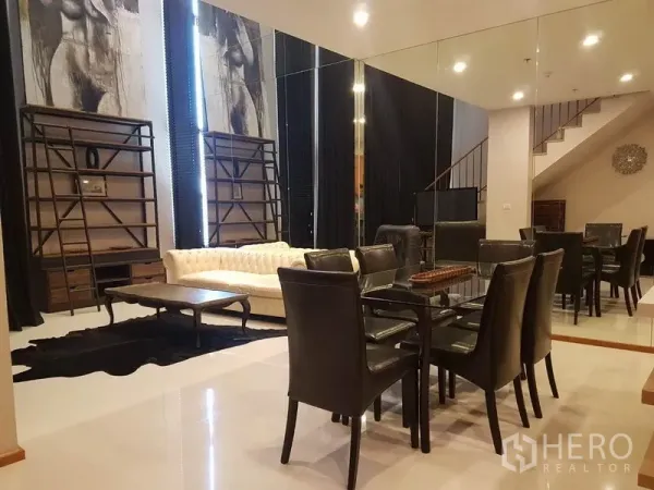 公寓 出租或出售在Khlong Toei, Bangkok - 用餐区配玻璃餐桌与镜面墙，连接挑高客厅与沙发。