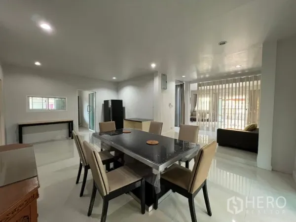 Detached House for rent in Bang Kapi, Bangkok - Open-plan dining area with six-seat table, recessed lighting and view to the living space.