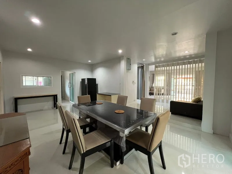 Detached House for rent in Bang Kapi, Bangkok - Open-plan dining area with six-seat table, recessed lighting and view to the living space.