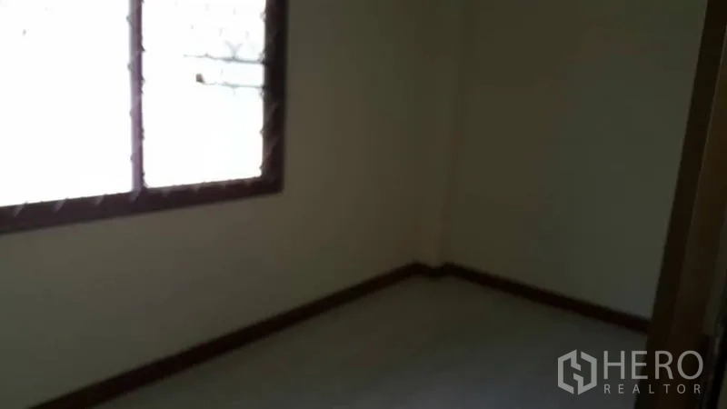 Detached House for rent in Khlong Toei, Bangkok - Compact bedroom with a window and plain walls, ready for renovation.