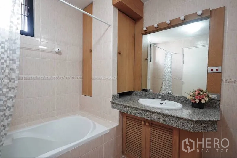 Detached House for rent in Chatuchak, Bangkok - Bathroom with bathtub, granite vanity, illuminated mirror, and tiled walls.