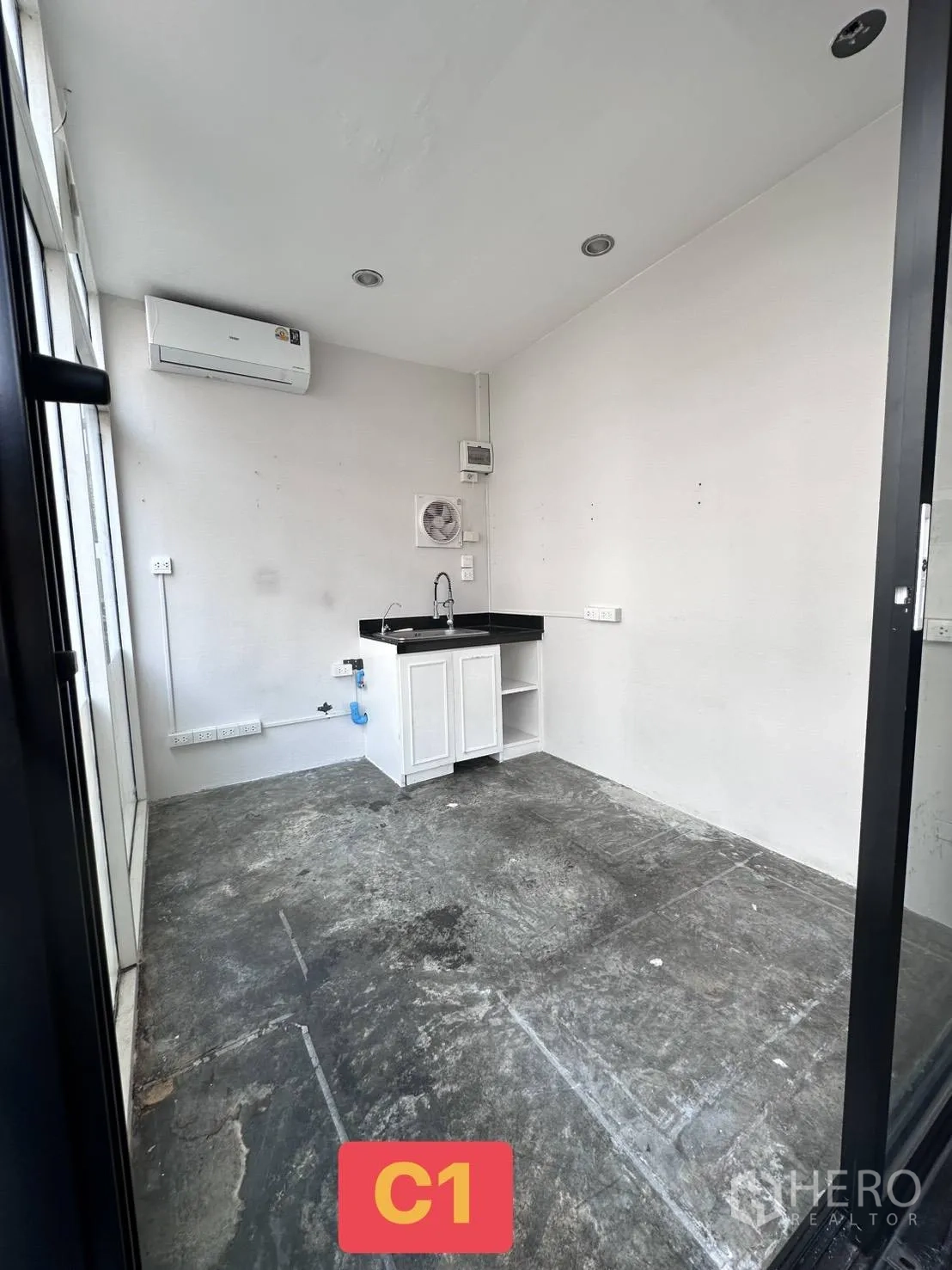 Retail Space for rent in Watthana, Bangkok - Small shop space with air conditioner, exhaust fan, recessed lights, and concrete flooring.