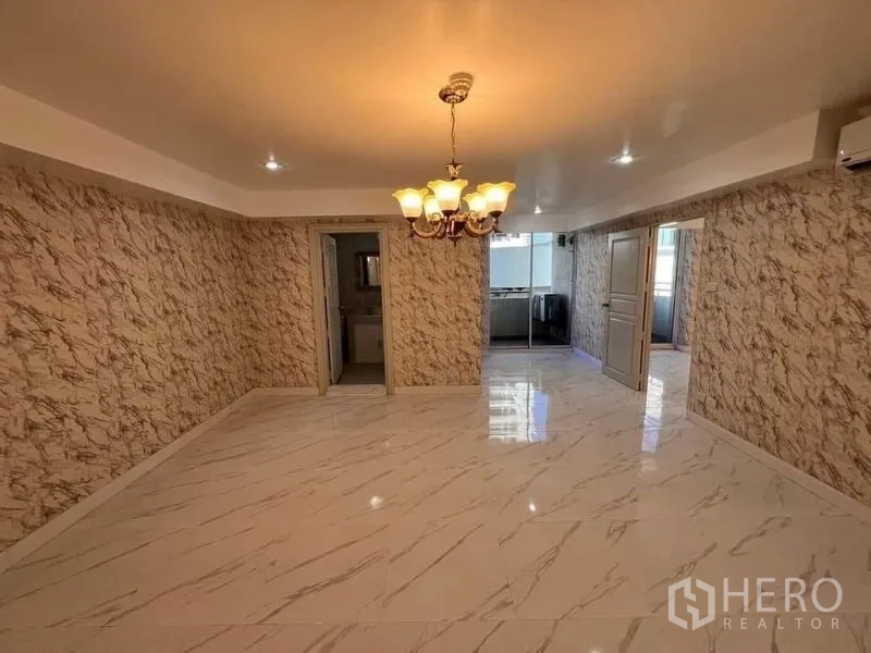 Condominium for rent or sale in Watthana, Bangkok - Large multipurpose room with marble-effect tiles and classic chandelier.