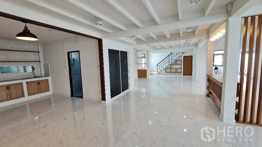 Detached House for rent in Lat Phrao, Bangkok - Open-plan ground floor with kitchenette, pendant lights and glossy floors.