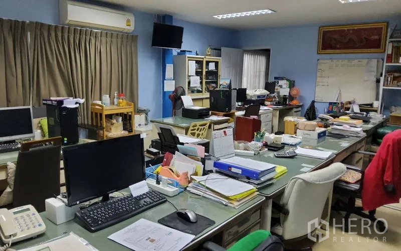 Warehouse for sale in Mueang Nonthaburi, Nonthaburi - Open-plan office with desks, computers and fluorescent lighting.