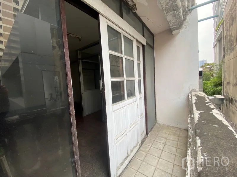 Retail Space for rent in Watthana, Bangkok - Balcony with sliding door and city-side outlook between neighboring buildings.