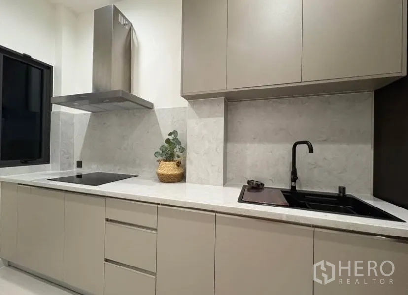 บ้านเดี่ยว for rent in Suan Luang, Bangkok - ครัวไทยแยก เคาน์เตอร์หิน เตาไฟฟ้า เครื่องดูดควัน และอ่างล้างจานสีดำ
