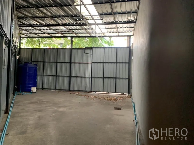 店屋 出售在Lat Phrao, Bangkok - 后院带金属屋顶与大门，配水箱，适合装卸或杂物。