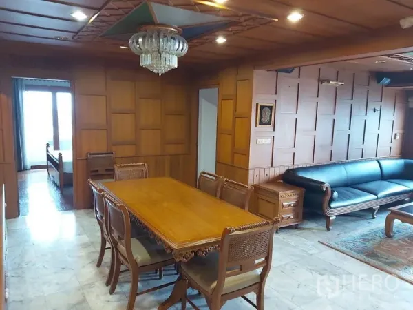 公寓 出租在Samphanthawong, Bangkok - 实木墙面的餐厅，吊灯、雕花餐桌，与相连的客厅。