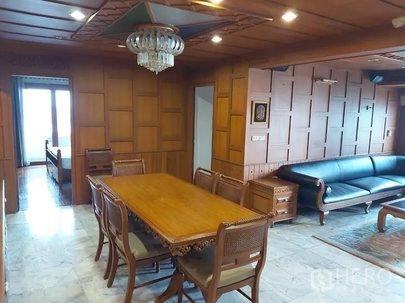 公寓 出租在Samphanthawong, Bangkok - 实木墙面的餐厅，吊灯、雕花餐桌，与相连的客厅。