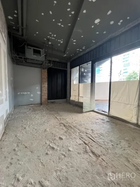 零售空间 出租在Khlong Toei, Bangkok - 毛坯室内空间，挑高天花、外露管线与落地窗采光。