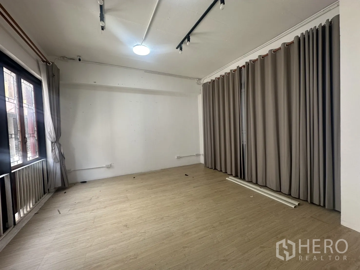 带办公室的家 出租在Pathum Wan, Bangkok - 多功能房，木纹地面与整墙窗帘、阳台式窗户。