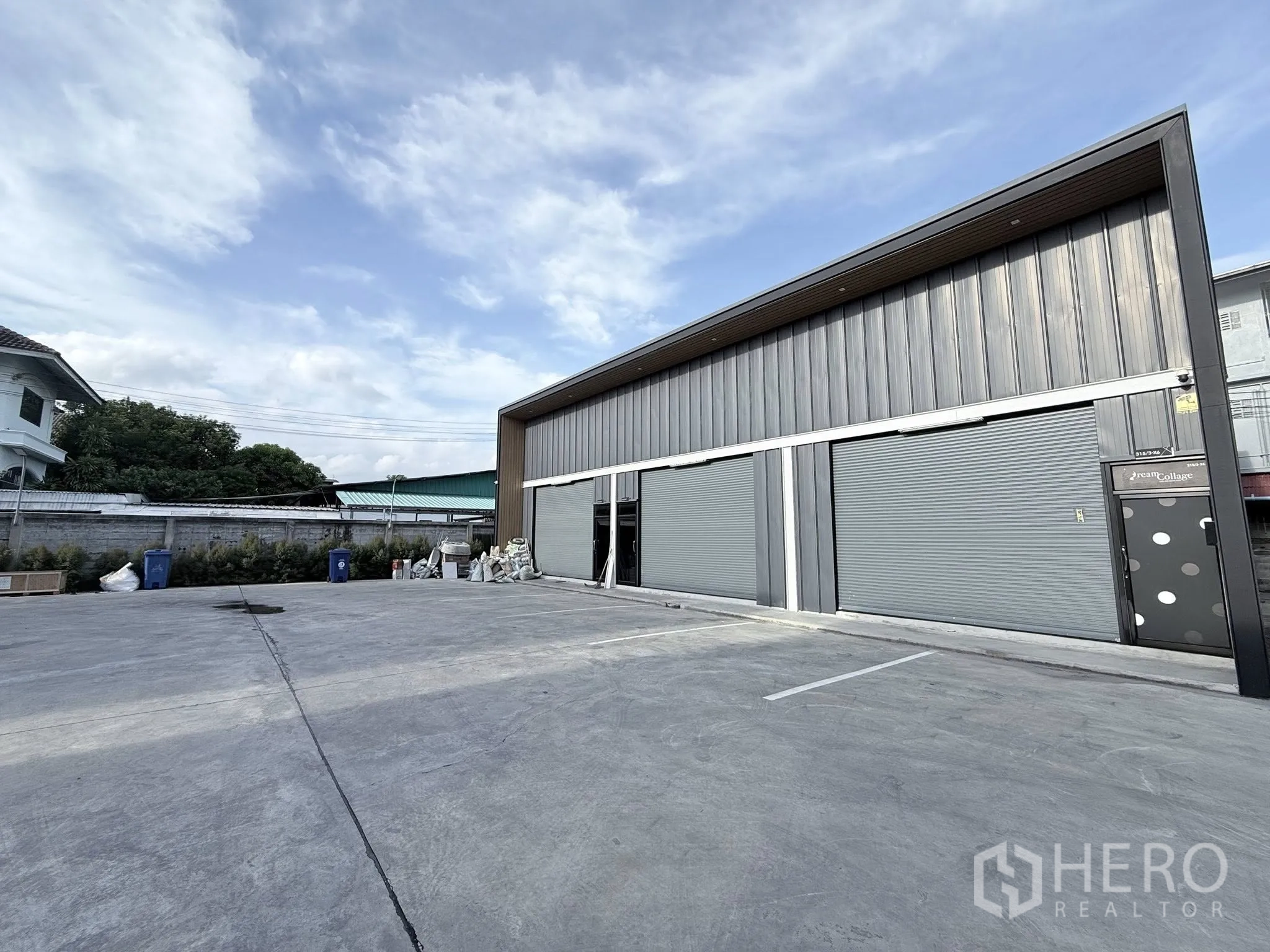Warehouse for rent in Suan Luang, Bangkok - Modern warehouse exterior with three roller shutters and a wide concrete forecourt for parking in Suan Luang, Bangkok.