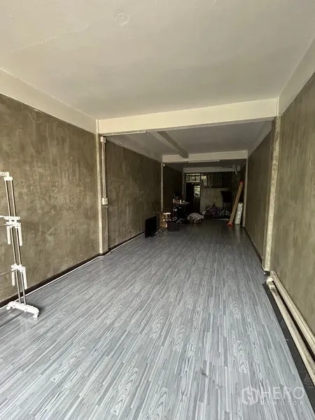 Shophouse for rent in Watthana, Bangkok - Renovated room with gray vinyl flooring and cement-finish walls.