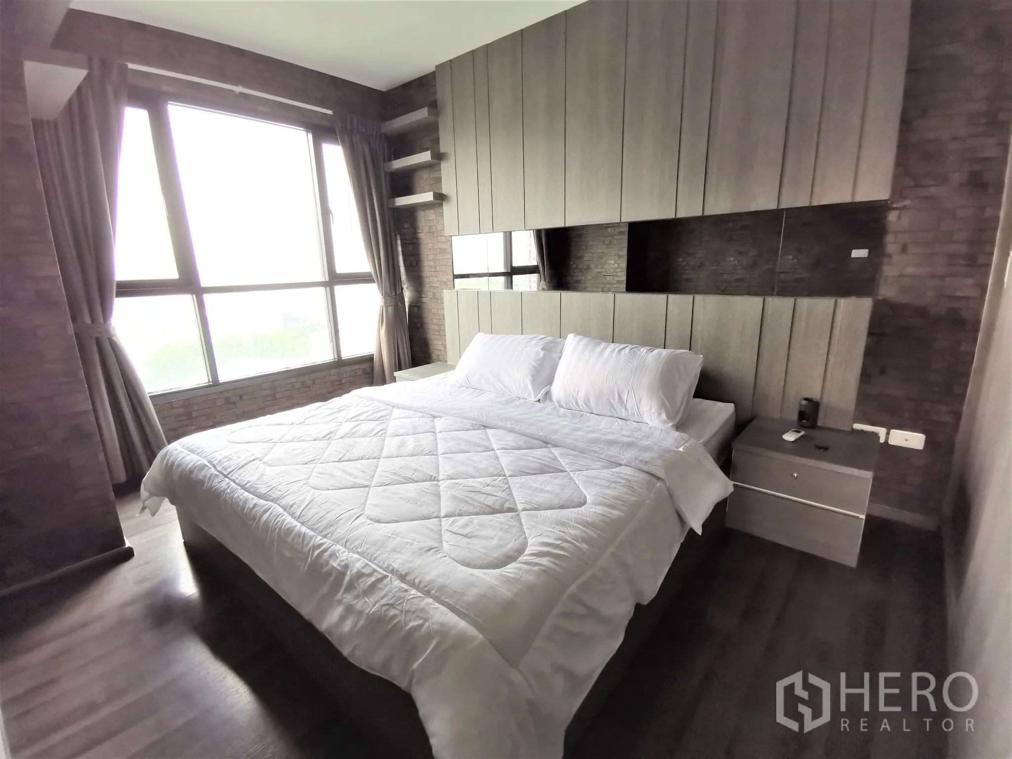 Condominium for rent or sale in Watthana, Bangkok - Master bedroom wide view with large window, curtains and matching bedside tables.