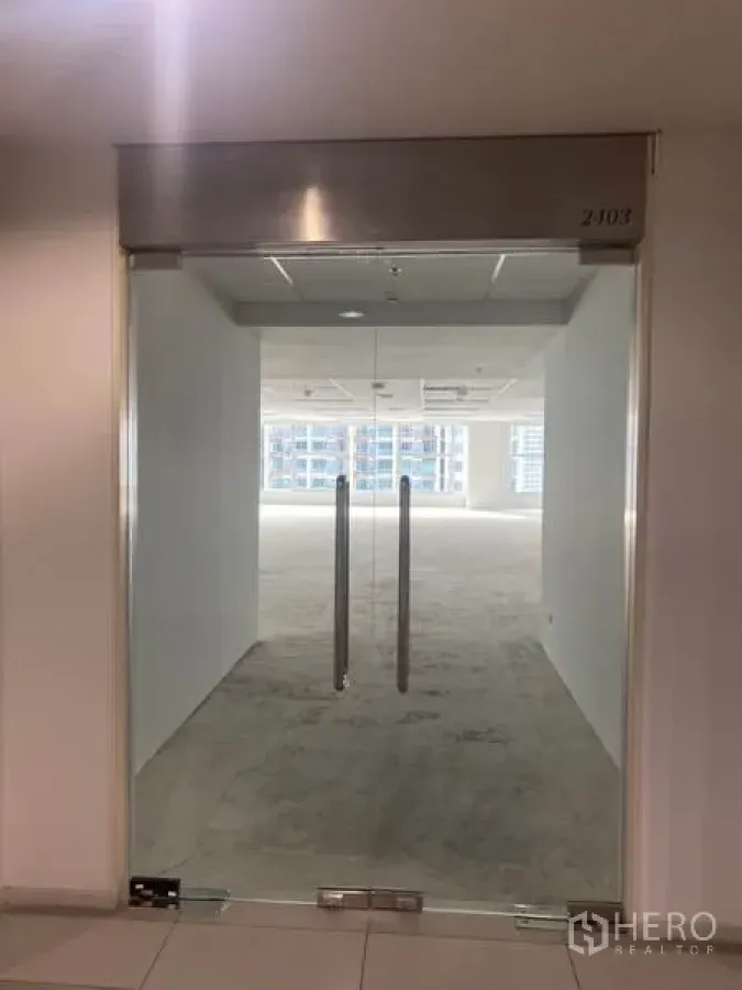 办公空间 出租在Bang Rak, Bangkok - 无框玻璃双门入口，通往是隆曼谷一处未装修的开放式办公空间，白墙与吊顶灯光明亮。