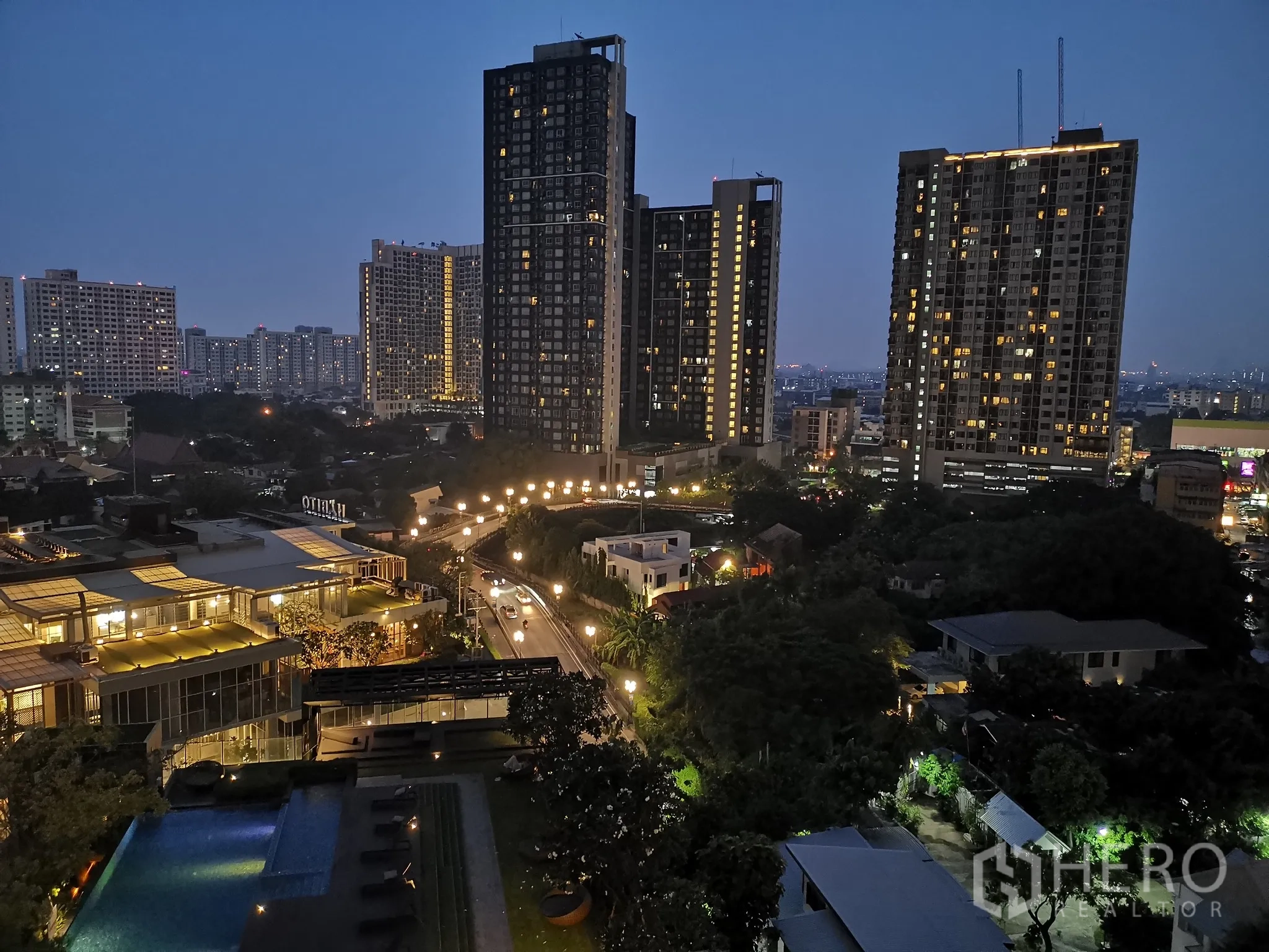 Condominium for rent or sale in Watthana, Bangkok - Night cityscape from the condo with illuminated pool and high-rise buildings.