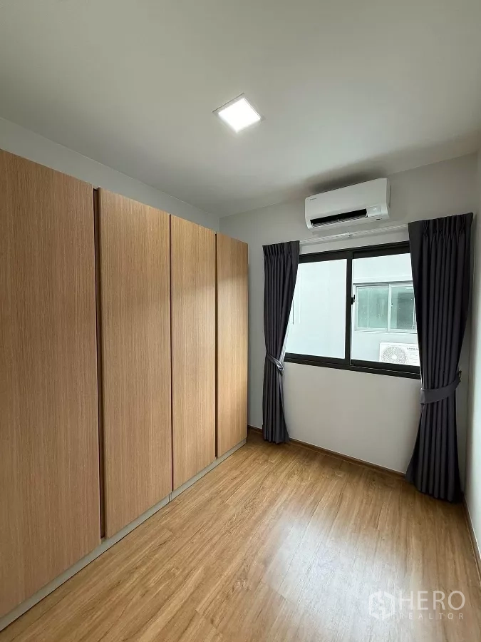 Townhouse for rent in Bang Phli, Samut Prakan - Third bedroom or study with full-height wardrobes and side window.