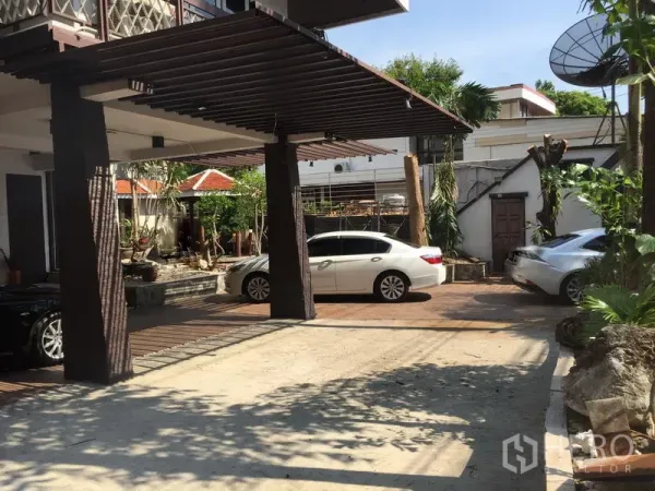 Retail Space for rent in Khlong Toei, Bangkok - Driveway with pergola-style carport, several parked cars and landscaped garden area.