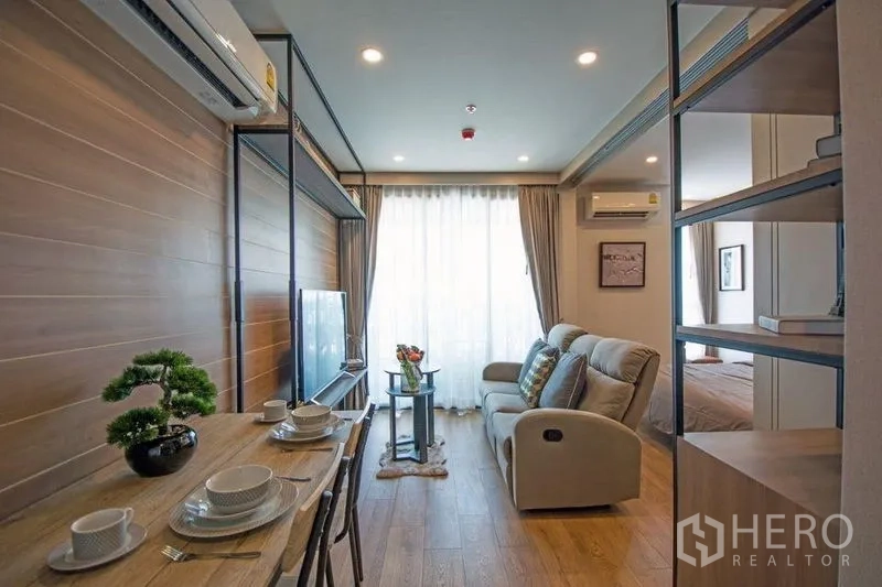 公寓 出售在Ratchathewi, Bangkok - 餐桌与客厅一体空间，大窗、沙发与内置书架
