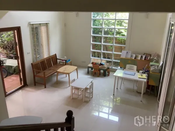 联排别墅 出售在Huai Khwang, Bangkok - 一层明亮客厅，亮面地砖，大型玻璃砖窗，连接花园。