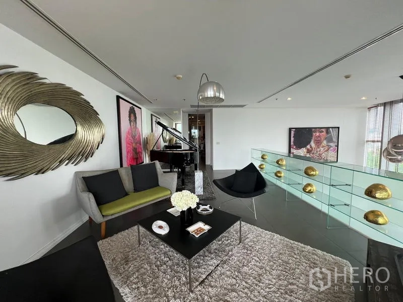 Condominium for sale in Khlong San, Bangkok - Sitting area with grand piano, contemporary art, and glass balustrade corridor.