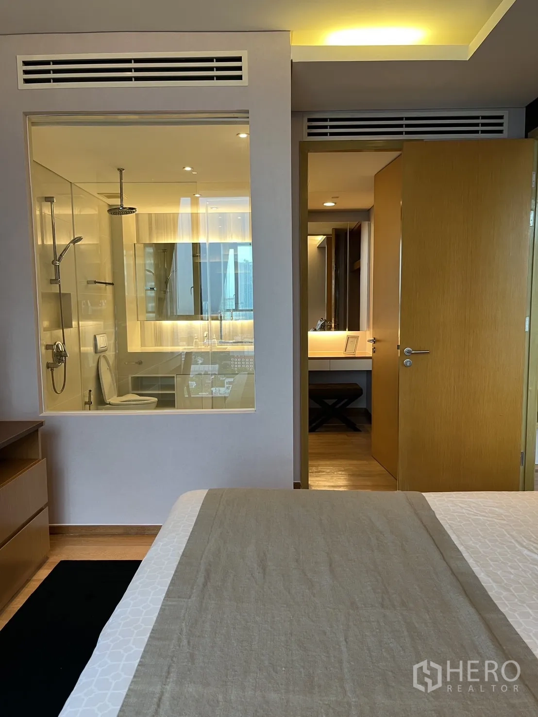 Condominium for rent in Watthana, Bangkok - Bedroom view into the bathroom through a glass partition with rain shower.