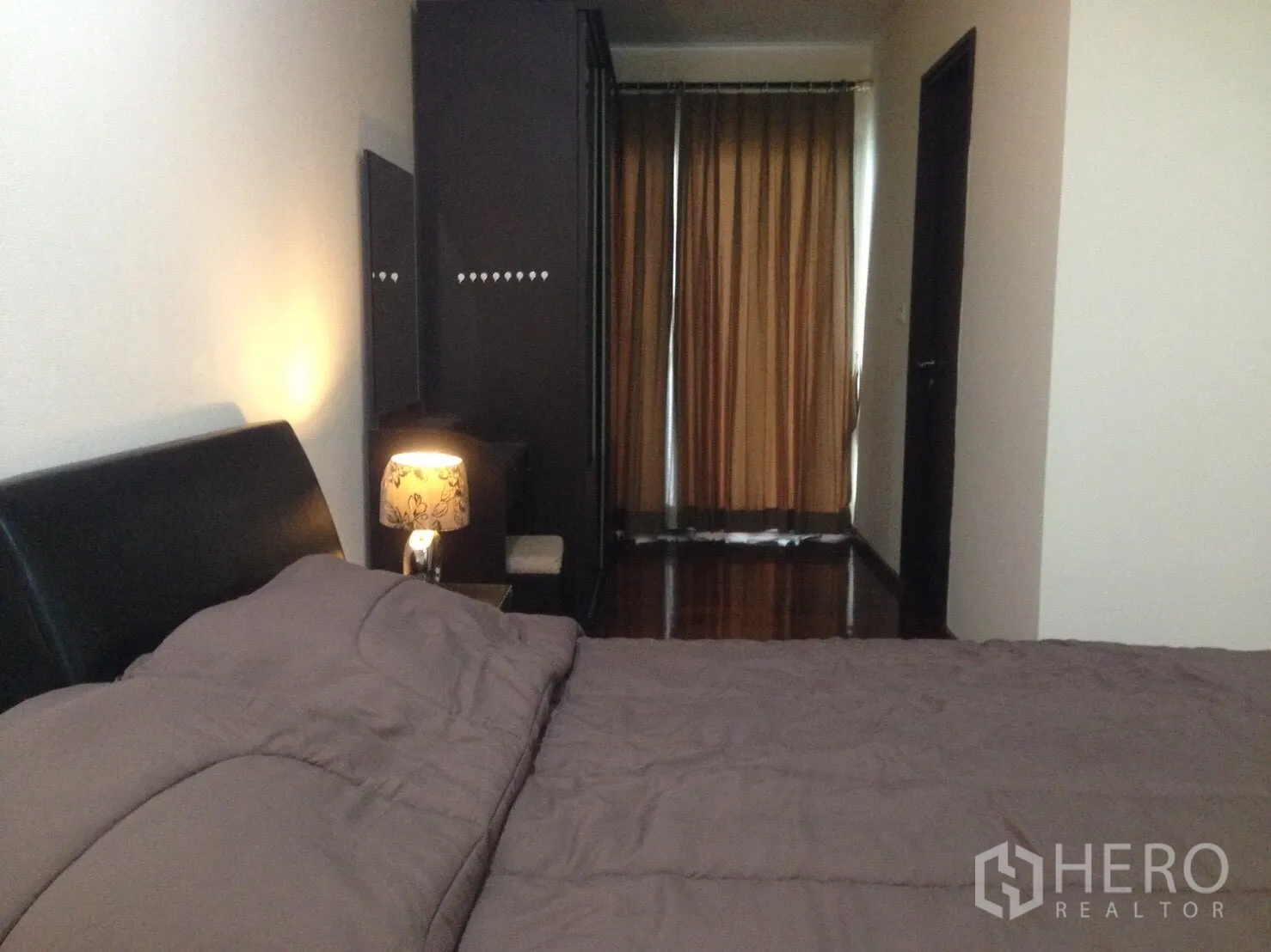 公寓 出租在Watthana, Bangkok - 温馨卧室，配双人床、床头灯、衣柜与遮光窗帘。
