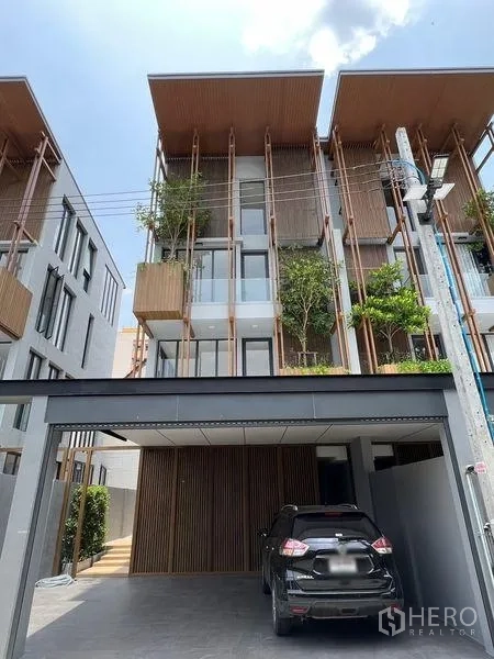 带办公室的家 出售在Wang Thonglang, Bangkok - 当代联排外观，竖向木格与绿化花槽，配双车位雨棚车库。