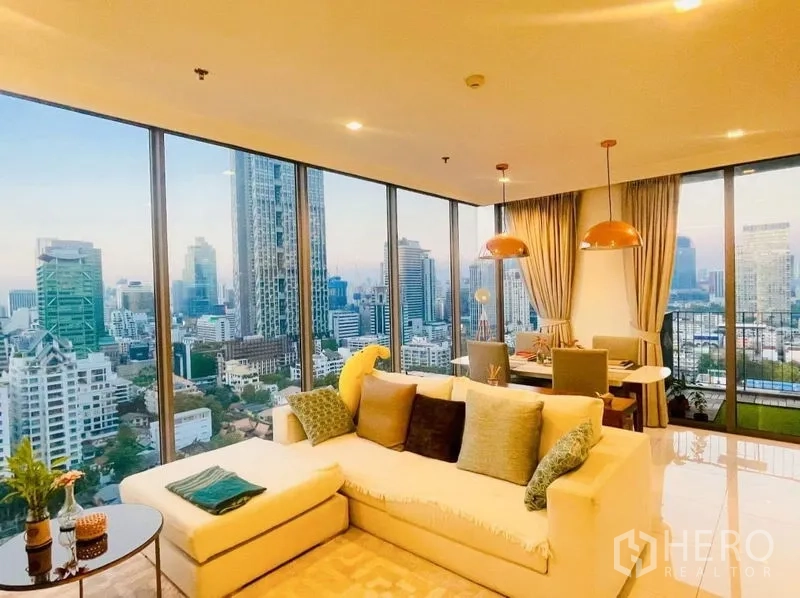 Condominium for rent or sale in Sathon, Bangkok - Corner living and dining room with floor-to-ceiling windows and Bangkok skyline views.