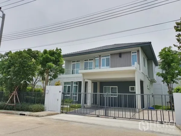 Detached House for rent in Prawet, Bangkok - Front exterior of a two-storey detached house with sliding gate and driveway.