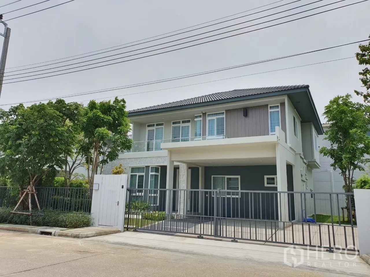 独立式住宅 出租在Prawet, Bangkok - 两层独栋别墅正立面，带滑动大门与车道。