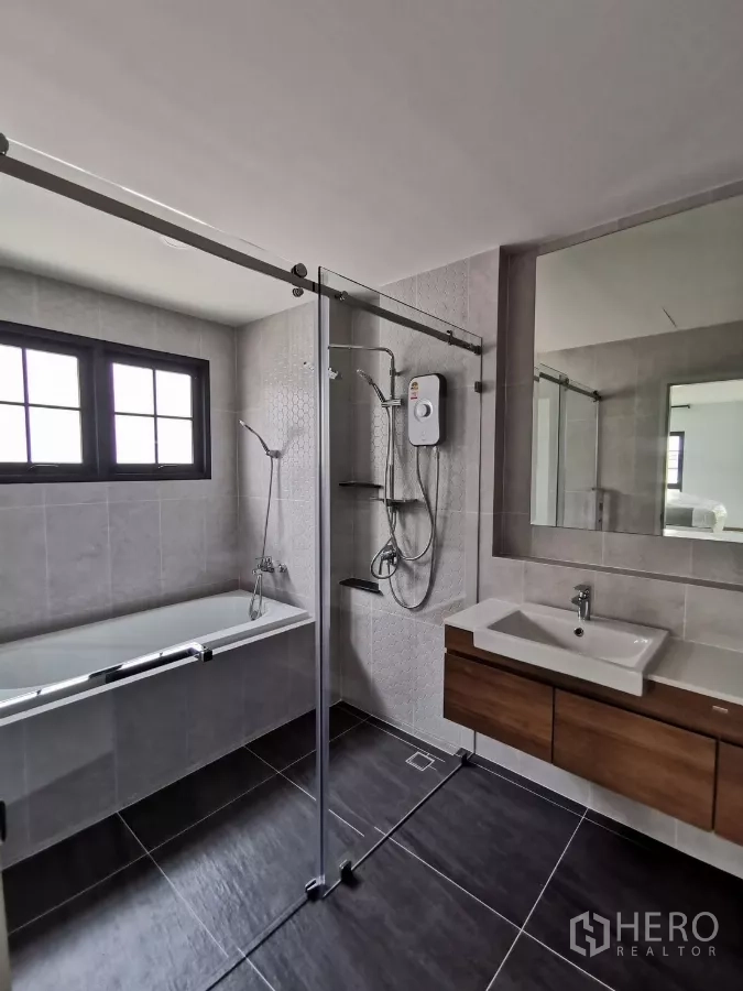 Detached House for rent in Bang Phli, Samut Prakan - Modern bathroom with bathtub, glass-enclosed shower and vanity.